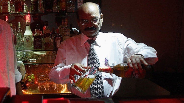 Un camarero sirviendo cerveza en un bar de Bombay, India 