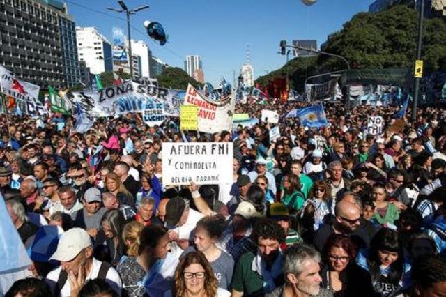 Manifestantes marchan hacia el obelisco durante una protesta contra las negociaciones del gobierno y el FMI,