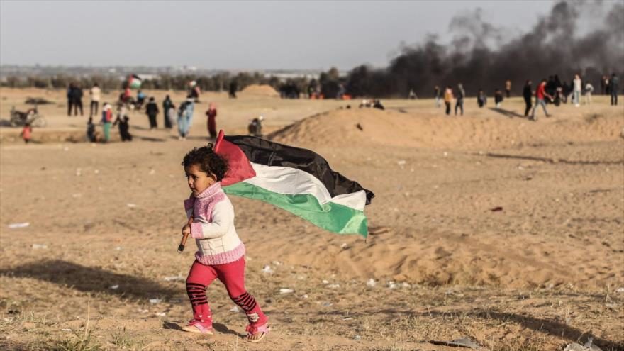 Un niño palestino lleva la bandera nacional de Palestina en una manifestación en la Franja de Gaza, 14 de mayo de 2018.