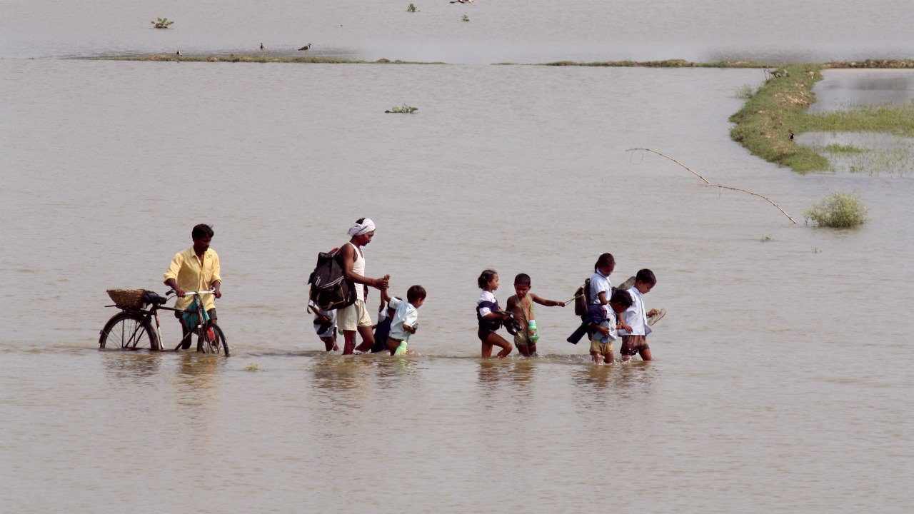 Children from a village near Lucknow, UP, walk home from school on submerged roads