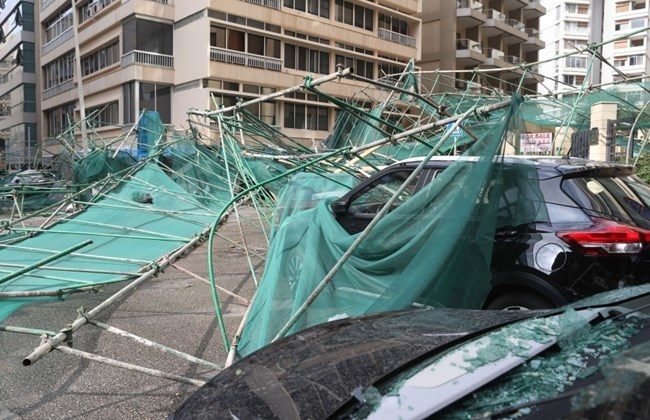 Cars are damaged after a scaffold falls over from the wind, in Raoucheh