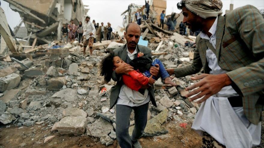 Un hombre lleva el cuerpo de una niña muerta en un bombardeo saudí en Saná, la capital de Yemen.