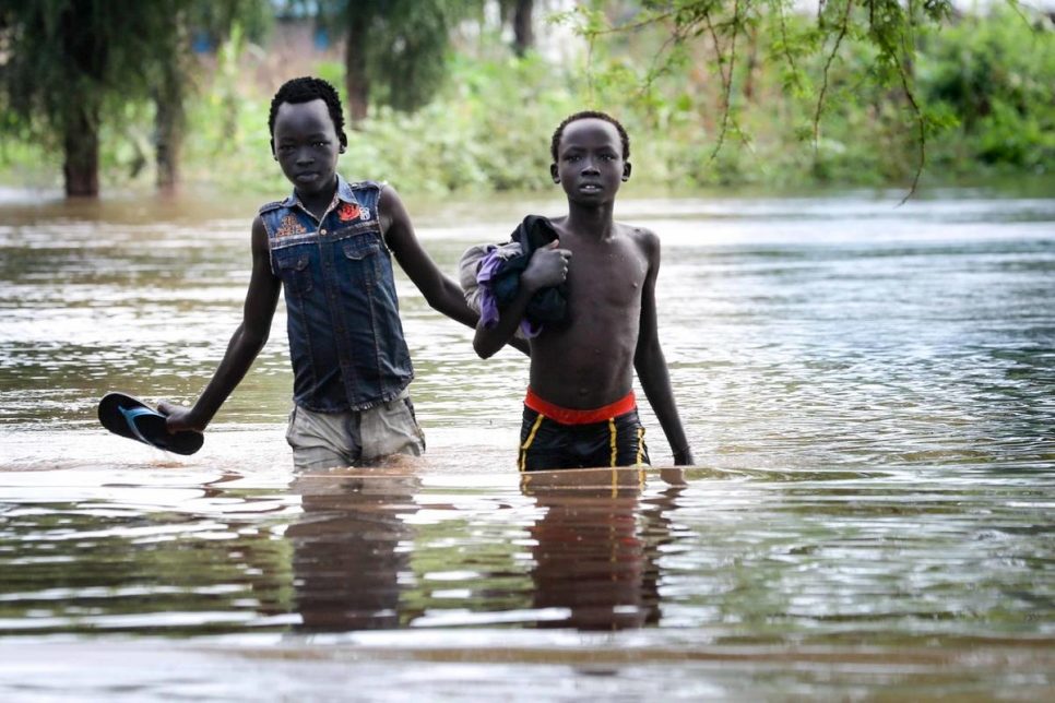 Dos niños se abren camino por una carretera inundada en el condado de Maban, en Sudán del Sur.