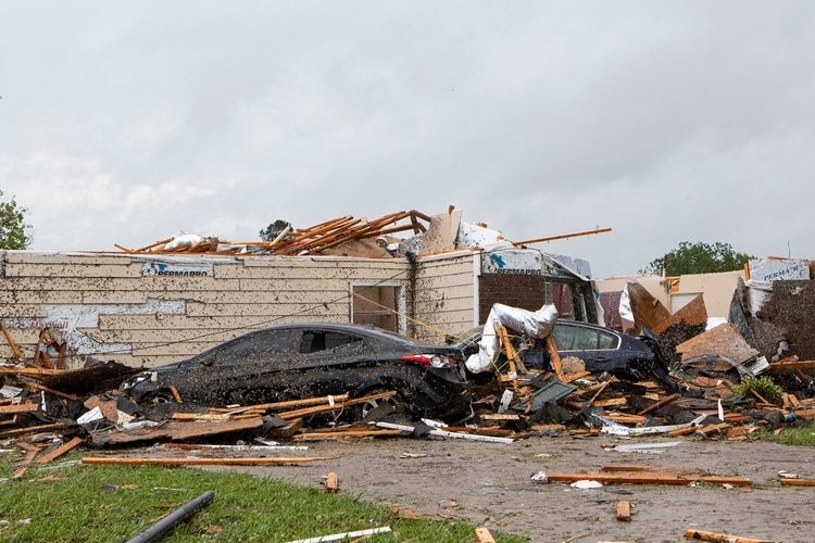 Esta imagen muestra una casa con el techo destruido junto a un par de automóviles tras el paso de un tornado en Monroe, Luisiana, el domingo 12 de abril de 2020.