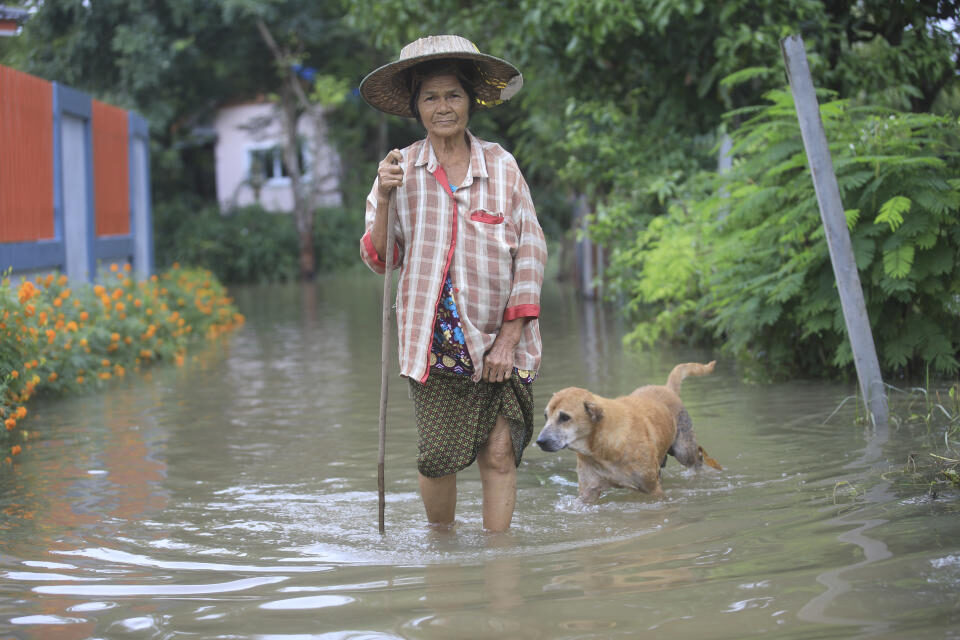 A woman wades through floodwaters in Nakhon Rachasima province, northeastern of Bangkok, Thailand, Monday, Oct. 18, 2021.