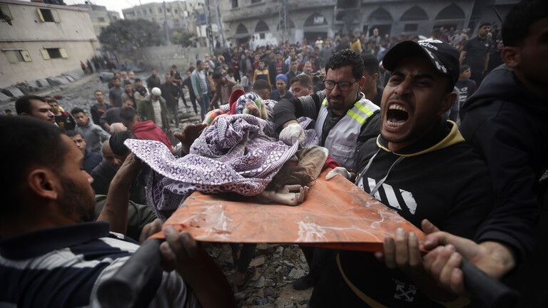 Palestinians carry a dead girl, found under the rubble of a destroyed building in Khan Younis, Gaza, December 7, 2023