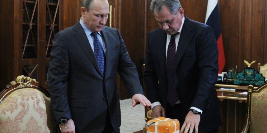 El presidente ruso, Vladimir Putin (izqda), y su ministro de Defensa, Sergei Shoigu presentando la caja negra del caza derribado por Turquía, el 8 de diciembre en Moscú