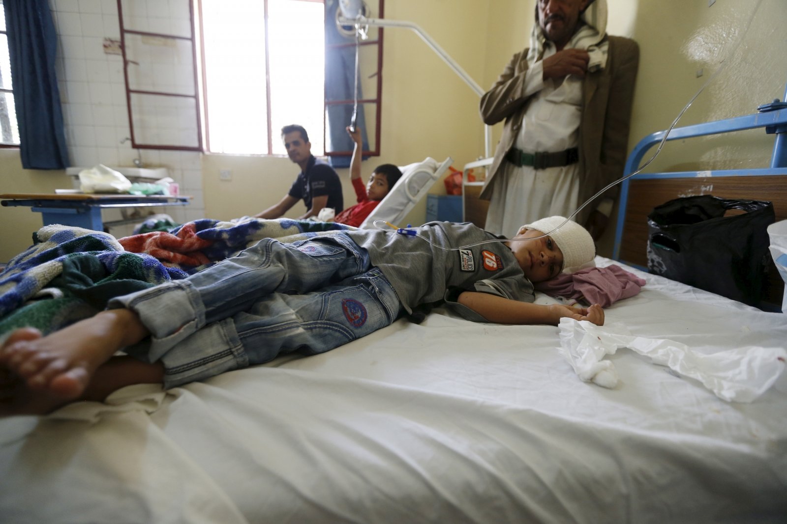 Un niño lesionado en un ataque suicida yace en la cama de un hospital de Sana'a de frente al inminente colapso de los servicios de salud en el país Yemen