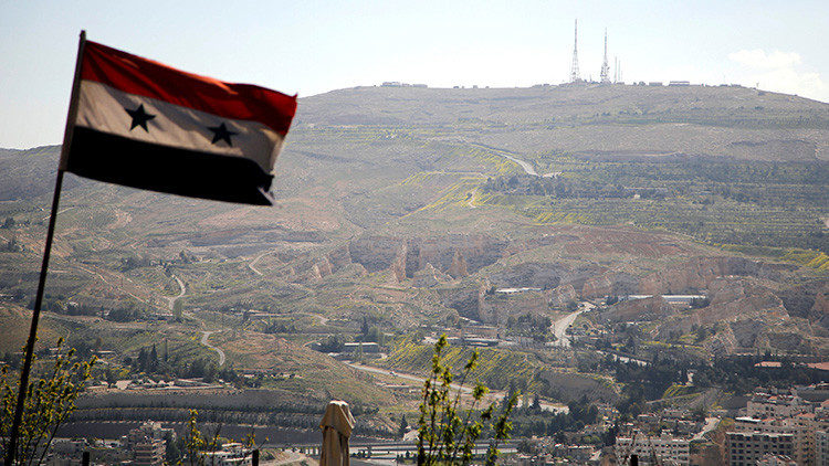 La bandera nacional de Siria ondea sobre el monte Qasioun a las afueras de Damasco, el 7 de abril de 2017.