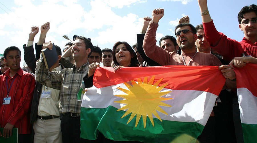 Young Kurdish Iraqis carry the flag of the Kurdistan Regional Government in Iraq