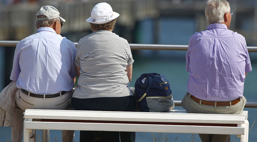 Elderly vacationers on the Baltic Sea coast promenade in Kuehlungsborn, Germany