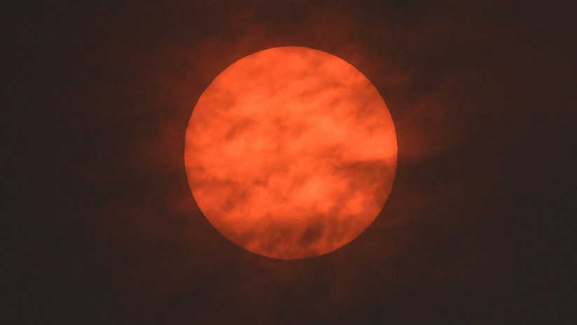 El sol, con un tono rojizo, visto después del amanecer Exeter, Reino Unido