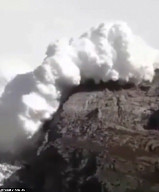 A huge plume of snow is seen tumbling towards the hikers and making its way over the mountains