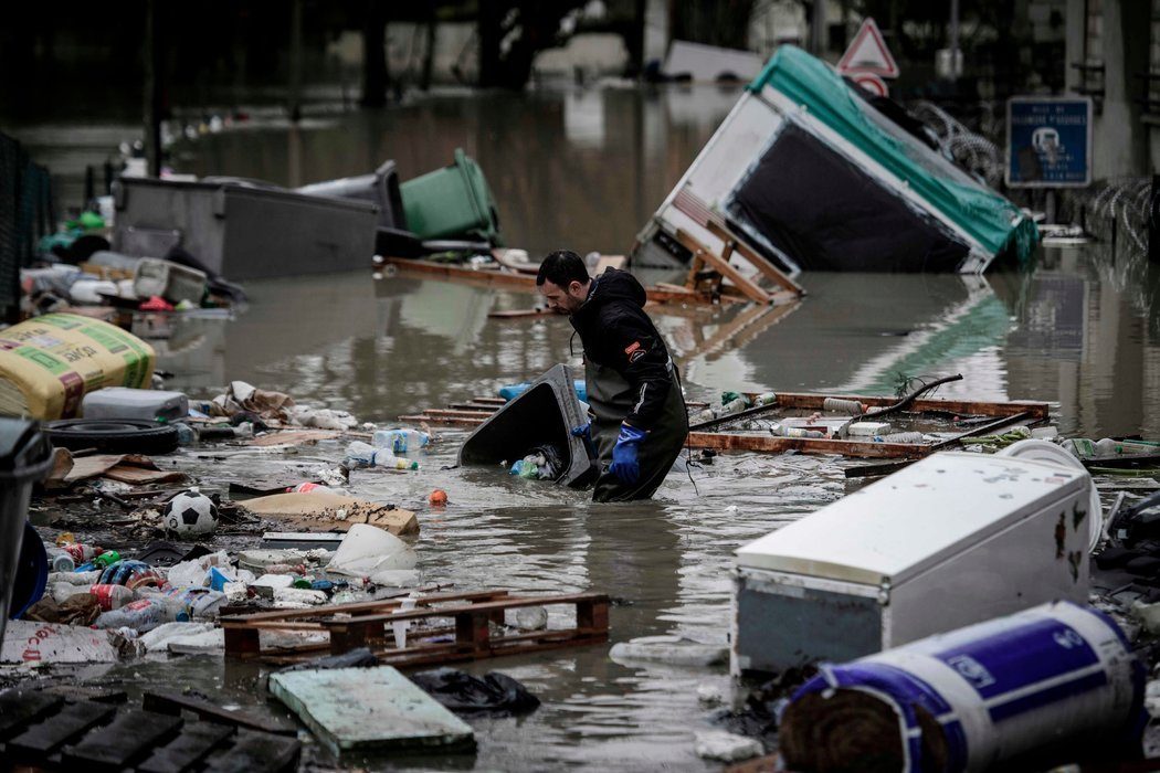 Un habitante de Villeneuve-Saint-Georges intenta despejar los escombros flotantes, el 25 de enero. Credit Philippe Lopez/Agence France-Presse — Getty Images