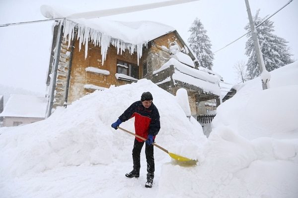 Un hombre abre un camino entre la nive en Delinice, Croacia