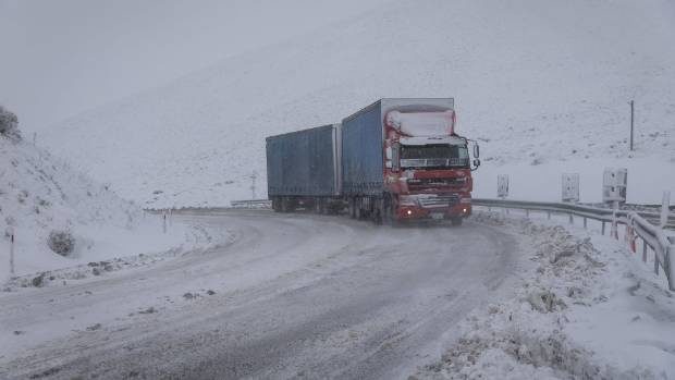A truck drives through heavy snow at the top of Porters Pass, in the Canterbury region.