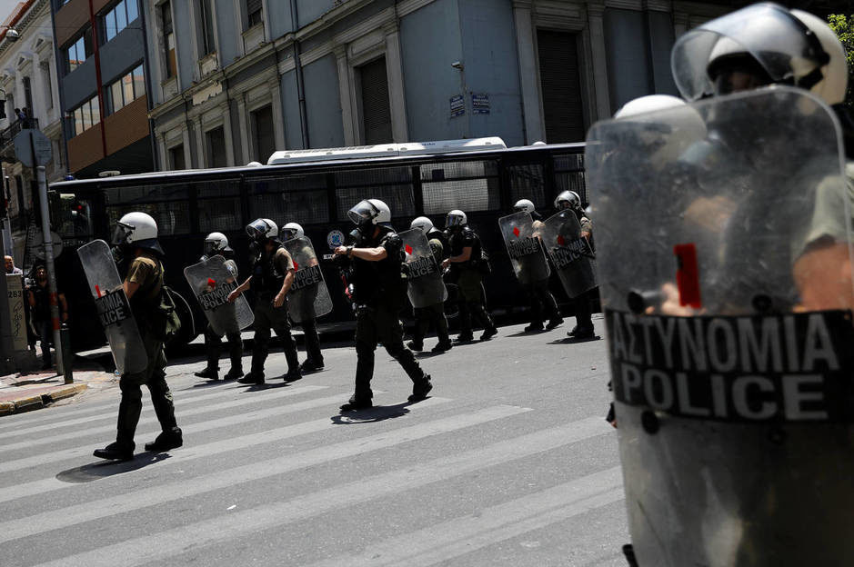 Policías antidisturbios protegen la Federación Helénica de Negocios durante la huelga.