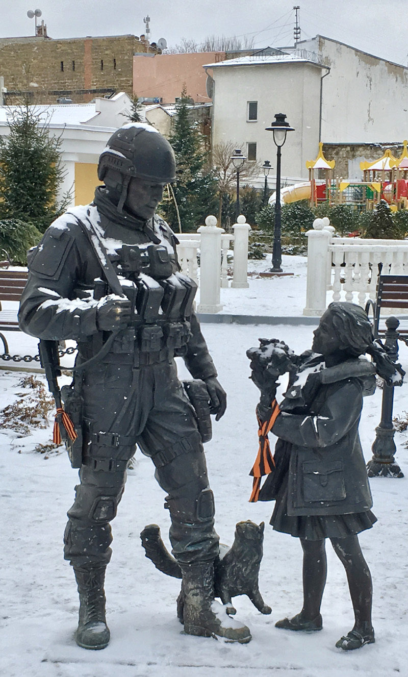 Locals hang orange and black “Victory” ribbons around statues symbolising peace, in Simferopol