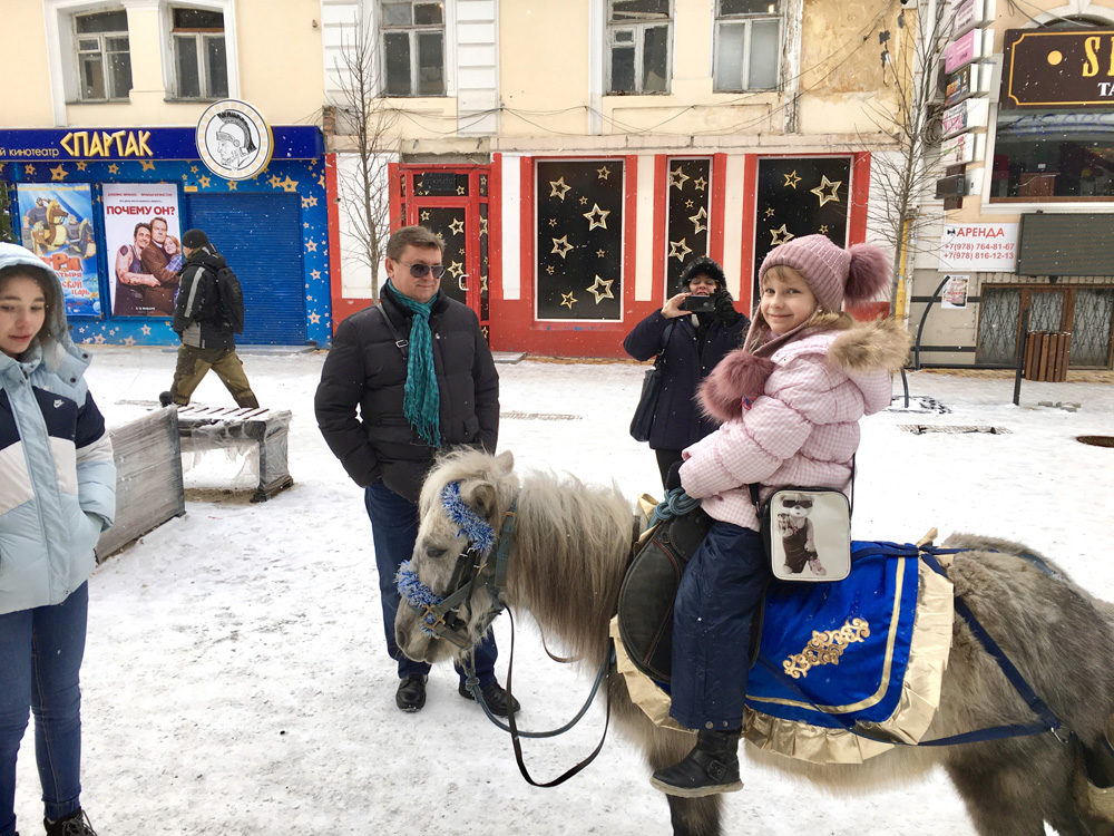 Young girl enjoys a pony ride through one of the main outdoor malls, Simferopol