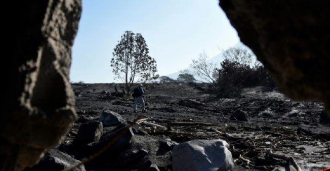 Un fotógrafo camina en el pueblo cubierto de ceniza de San Miguel Los Lotes, a unos 35 km al suroeste de Ciudad de Guatemala, el 11 de junio de 2018, después de una violenta erupción del volcán Fueg