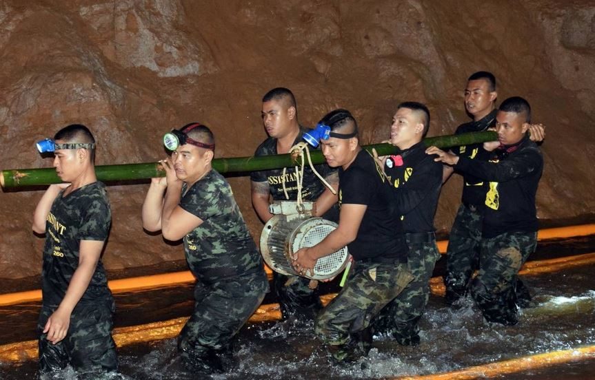 Miembros del equipo de rescte intentan drenar el agua de la cueva.