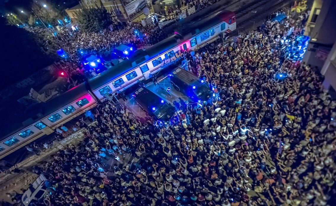Miles de manifestantes se concentran en el paso a nivel del Barrio de Santiago el Mayor, Murcia, ante una fuerte presencia policial.