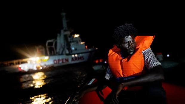 Un migrante se sienta a bordo del barco de rescate de la ONG Proactiva Open Arms en el mar Mediterráneo central.