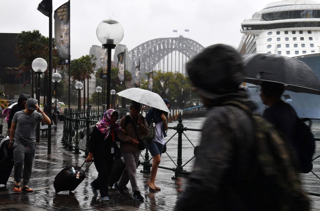 La gente se refugia de la lluvia mientras caminan en Circular Quay, en Sydney, el 28 de noviembre de 2018.