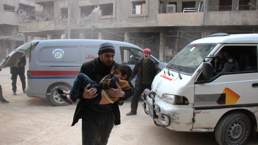Hombre con niño herido en Duma, Siria