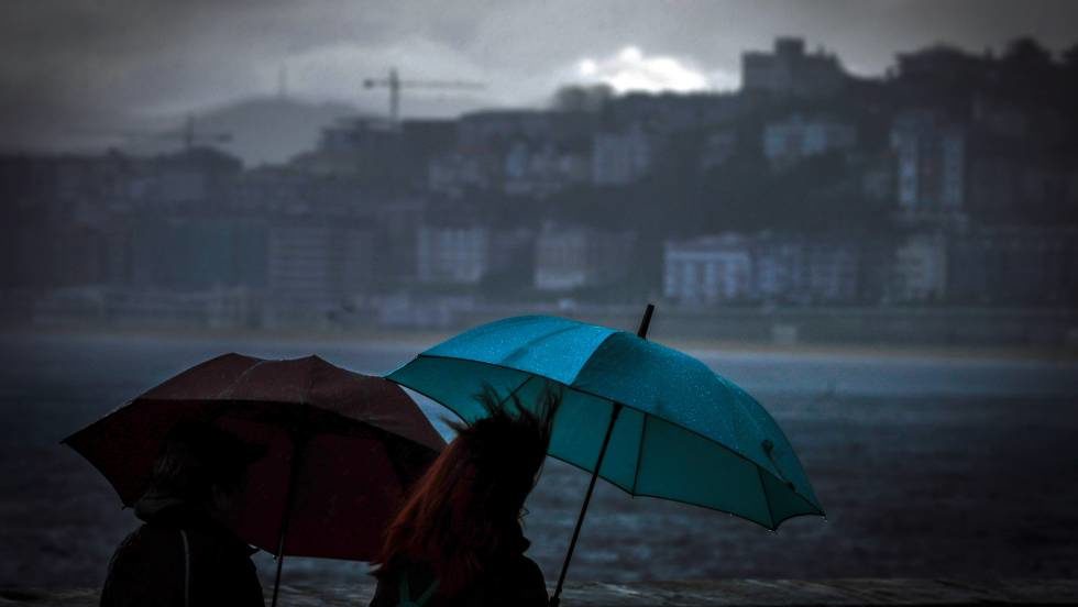 Dos personas se protegen de la lluvia el pasado enero, en San Sebastián. En vídeo, la lluvia y el frío regresan con la primavera recién estrenada.