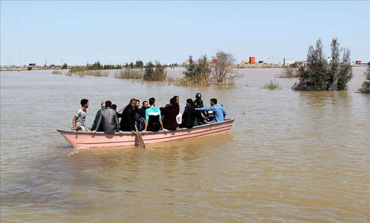 Iranís de la provincia de Golestan, anegada por las lluvias, en una barcaza a finales de marzo.