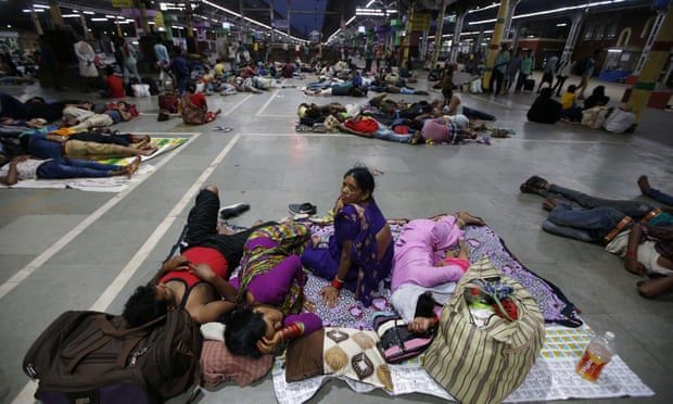 Stranded passengers rest inside a railway station after trains between Kolkata and Odisha were cancelled due to Cyclone Fani
