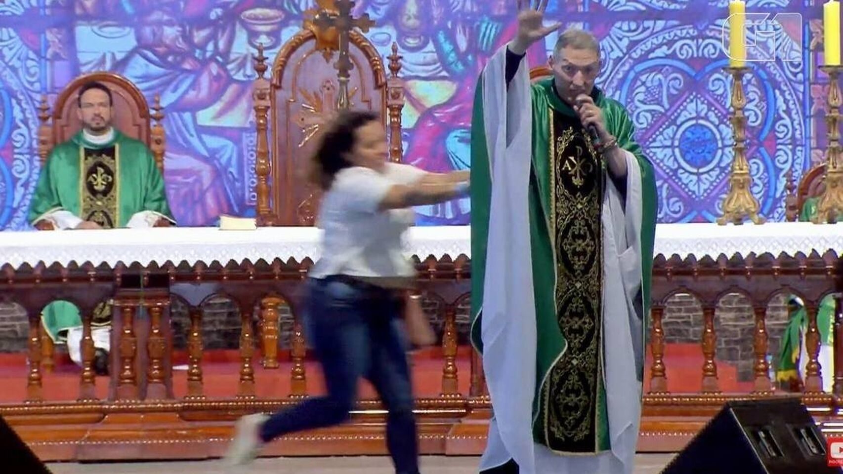 Mujer empuja a un cura y lo tira desde escenario durante misa en Brasil