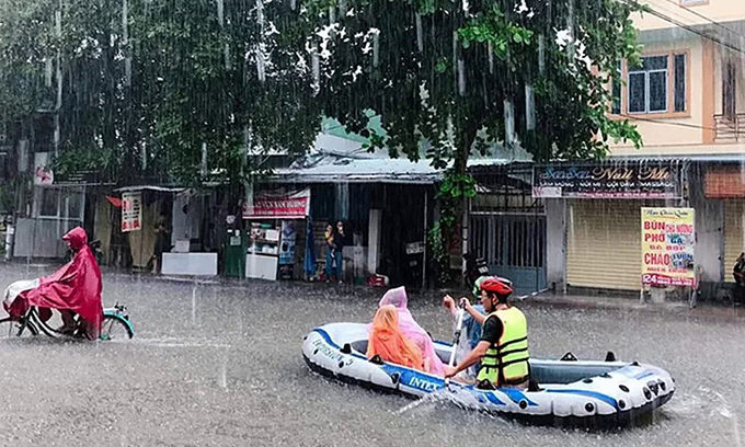 People travel on a flooded street in Vinh, Nghe An Province, October 17, 2019.