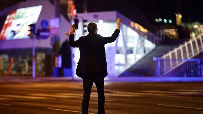 Un hombre levanta sus manos durante inspecciones tras el ataque. La policía en Austria