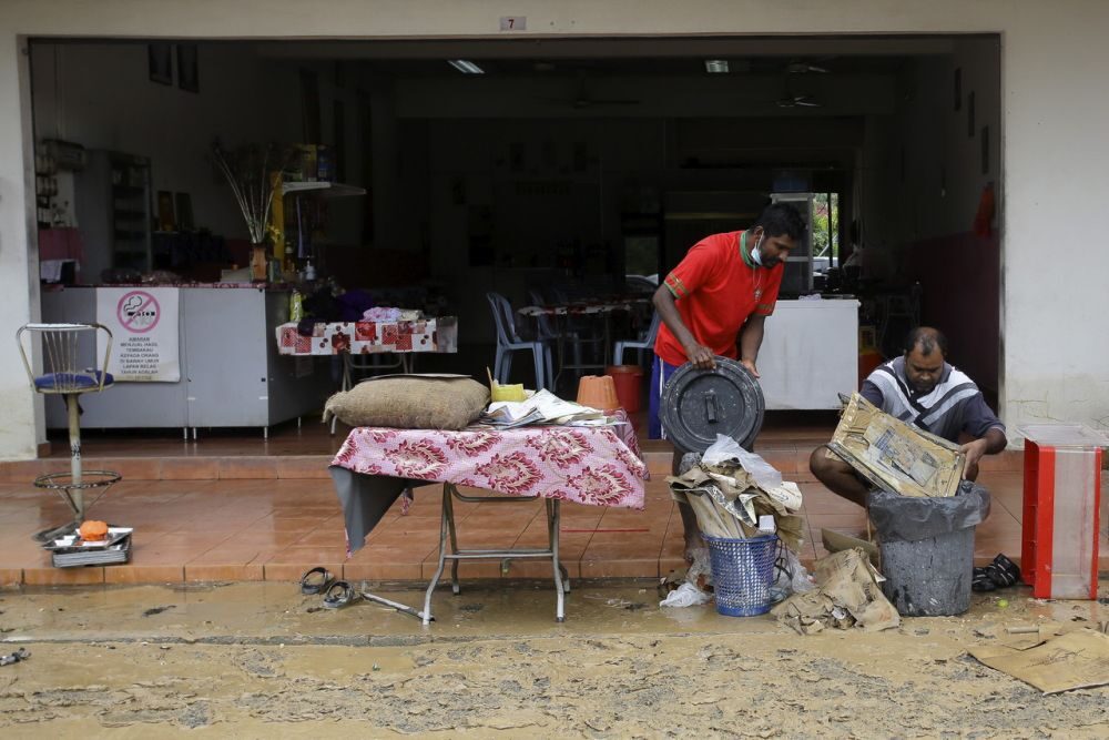Restaurant workers are seen salvaging items after Seremban was hit by flash floods earlier today.