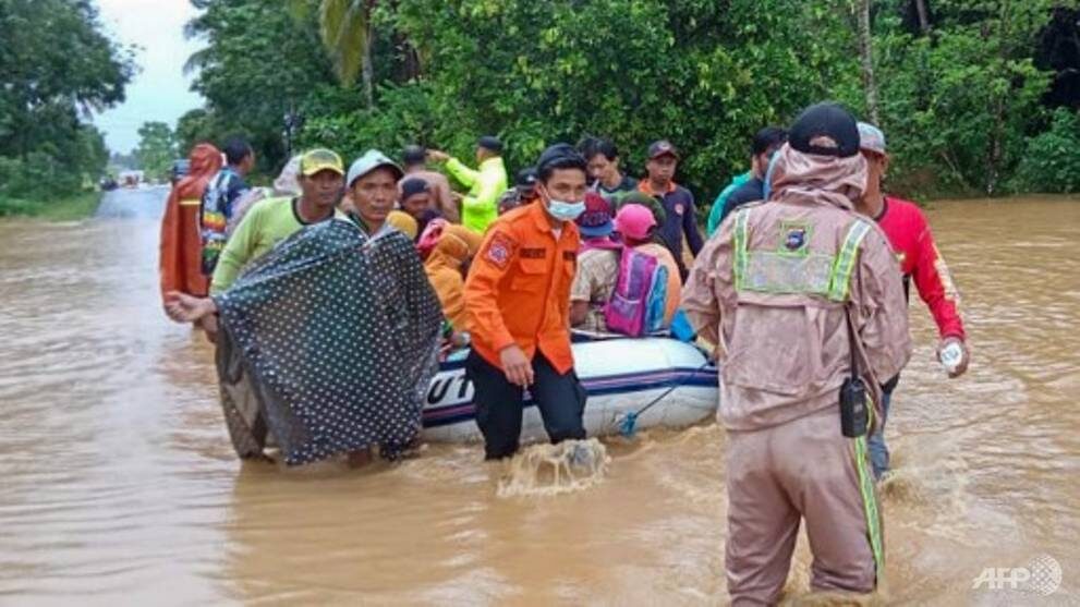 January 15, 2021, by the Indonesian National Board for Disaster Management (BNPB) shows rescuers evacuating villagers by rubber boat in a flooded area in the Tanah Laut districts, South Kalimantan.