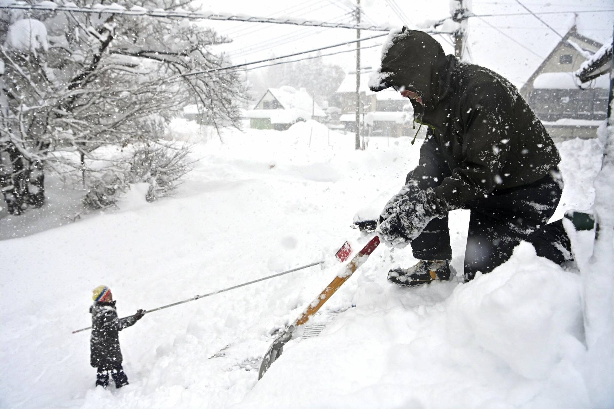 People remove snow from their house in Minakam