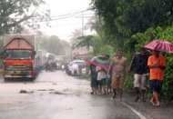  Varios motoristas y pasajeros intentan encontrar una ruta alternativa a una carretera inundada por la crecida de un río en Daraga, en la provincia de Albay, en el sur de Manila, el pasado 26 de julio
