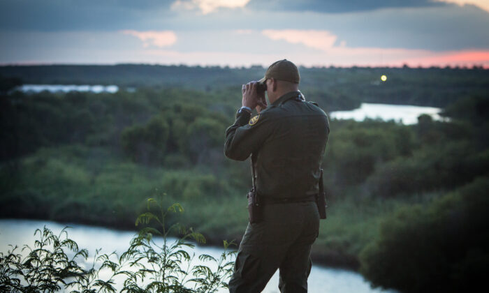 Un agente de la Patrulla Fronteriza observa a las personas que cruzan ilegalmente el Río Bravo desde México hacia la ciudad de Roma en Texas, el 31 de mayo de 2017.