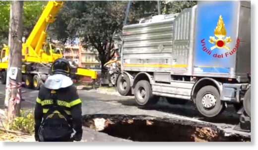 A truck is hauled from a hole 32 feet deep and 16 feet wide on Via dei Colli Portuensi in Rome.