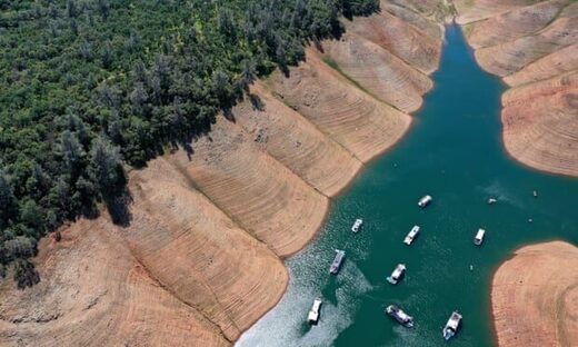 Houseboats are dwarfed by the steep banks of Lake Oroville