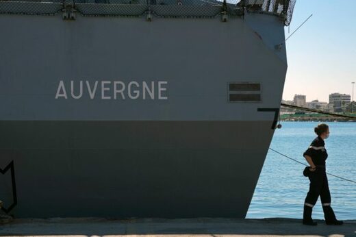 Una marinera pasa frente a la fragata francesa Auvergne en Larnaca, un puerto de Chipre.