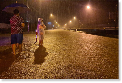 Residents at Bang Klong Luek in Hat Yai district of Songkhla watch as continuous rain floods a main road in Muang district in the early hours of Friday.
