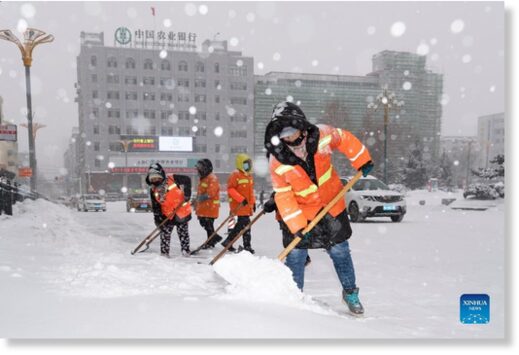 Sanitation workers clear snow from a street in Hegang City, northeast China