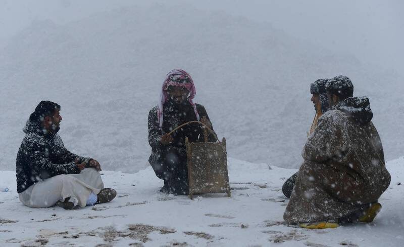 People enjoy a moment in the snow in Tabuk