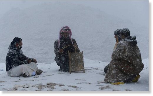 People enjoy a moment in the snow in Tabuk