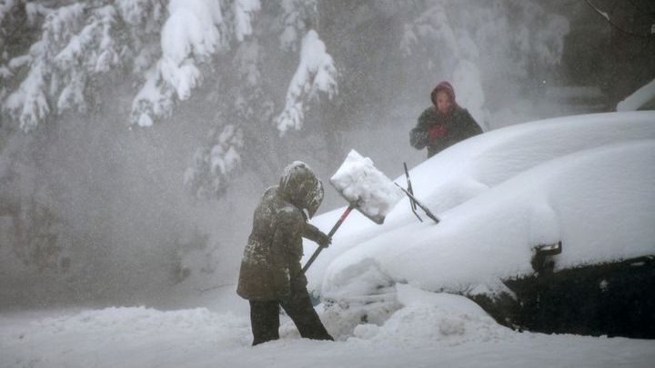 People try to clear snow around their car in Stony Brook, New York, on January 29, 2022.