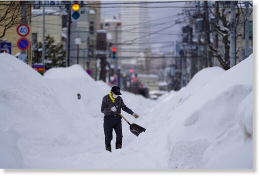 A man removes snow in Sapporo, Hokkaido, northern Japan, on Feb. 23, 2022, after heavy snow.