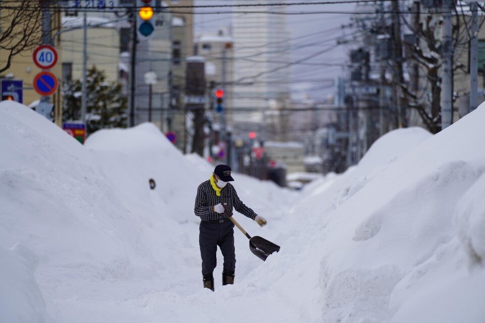 A man removes snow in Sapporo, Hokkaido, northern Japan, on Feb. 23, 2022, after heavy snow.